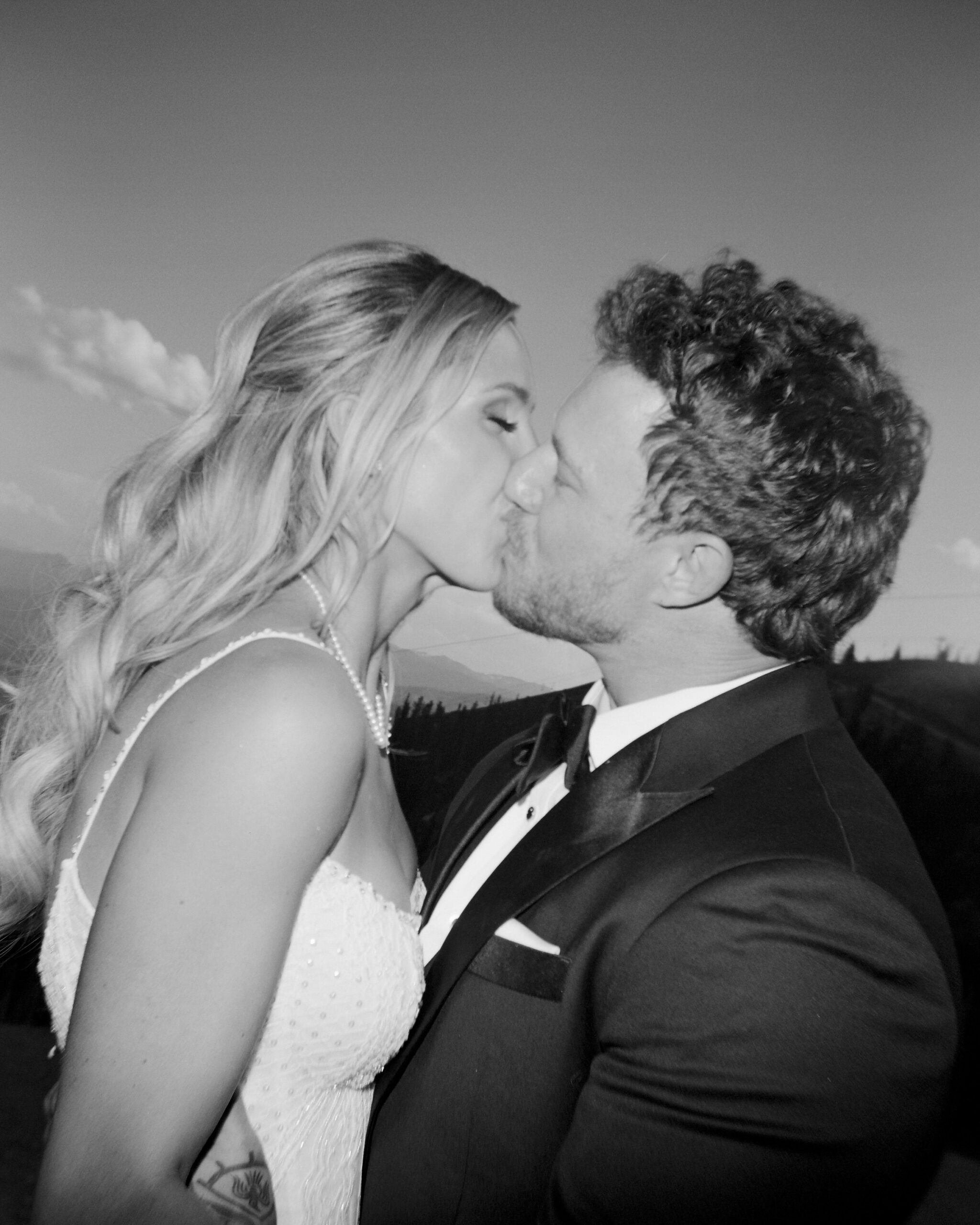 a couple kisses on their wedding day, ilford xp2 film, holga camera, jackson hole mountain resort